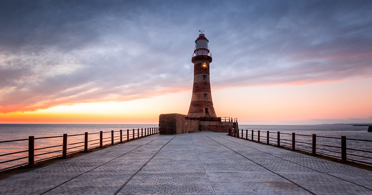 View of Roker Lighthouse during sunrise, located in Sunderland on the Northern Saints Trails.